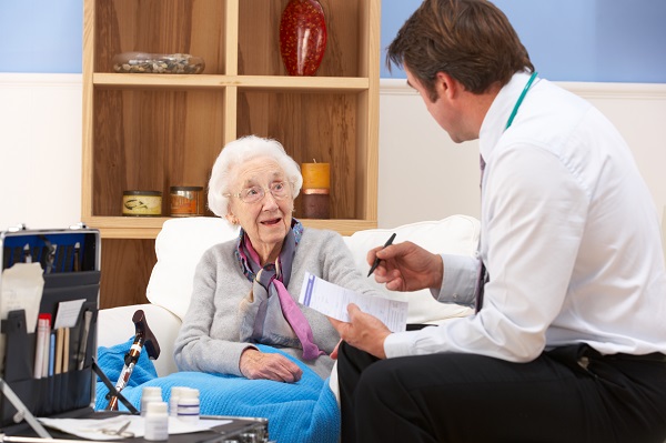 Male GP seeing an elderly woman at home