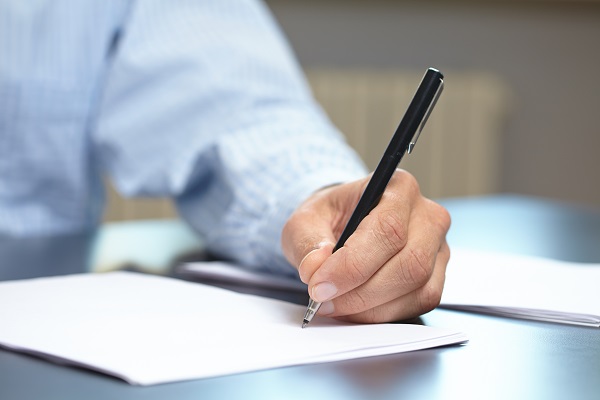 man writing in a diary