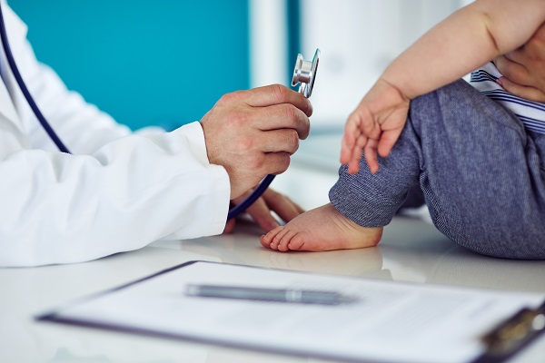 Doctor holding stethoscope to toddler